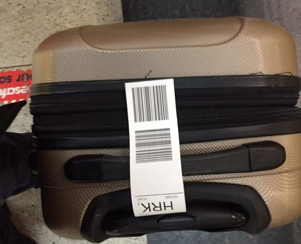 Bagaj takip fişi yapıştırılmış valiz yatık şekilde cihaza bırakılıyor. Sistem valiz barkodunu okuyarak işlem yapıyor.